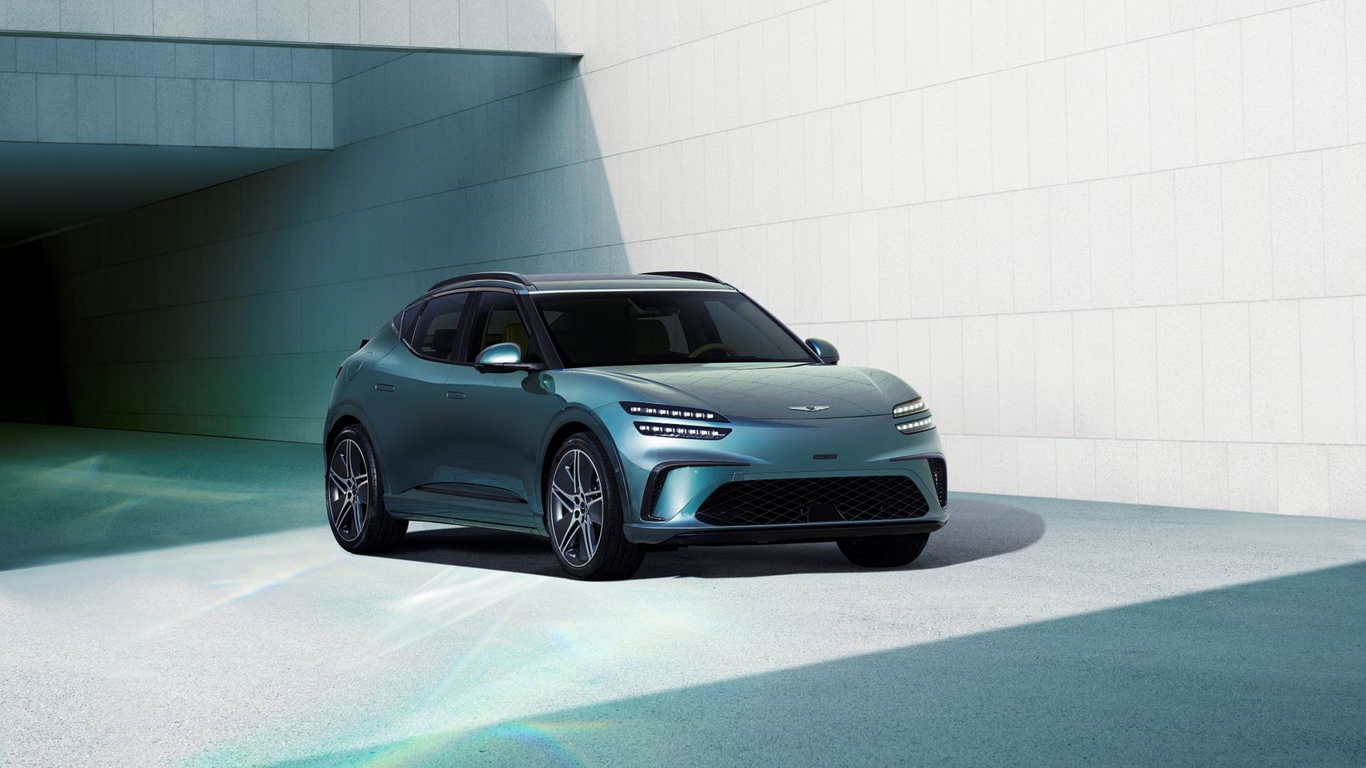 Vue de face d'un Genesis GV60 blanc, garé dans une rue française, mettant en valeur ses phares à double ligne et son design moderne.