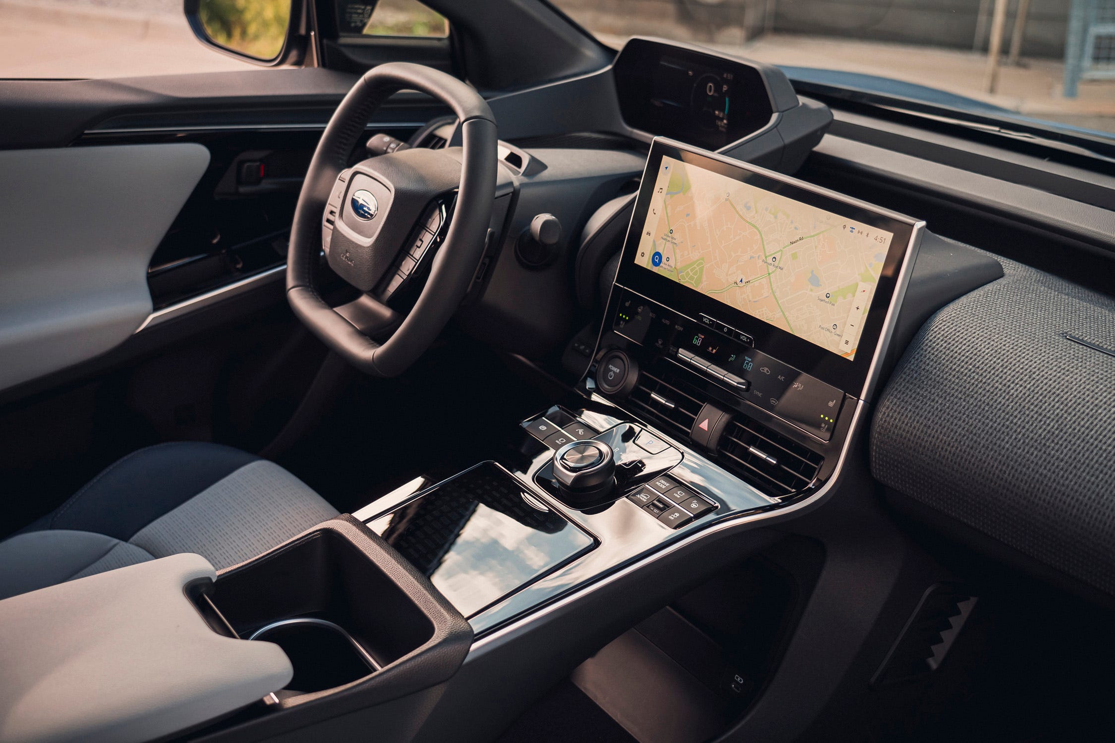 Intérieur d'un SUV électrique Subaru, montrant le tableau de bord numérique, l'écran tactile central et les sièges en cuir clair.