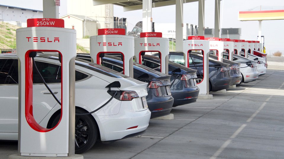 Vue d'une station Superchargeur Tesla avec des voitures en train de recharger.