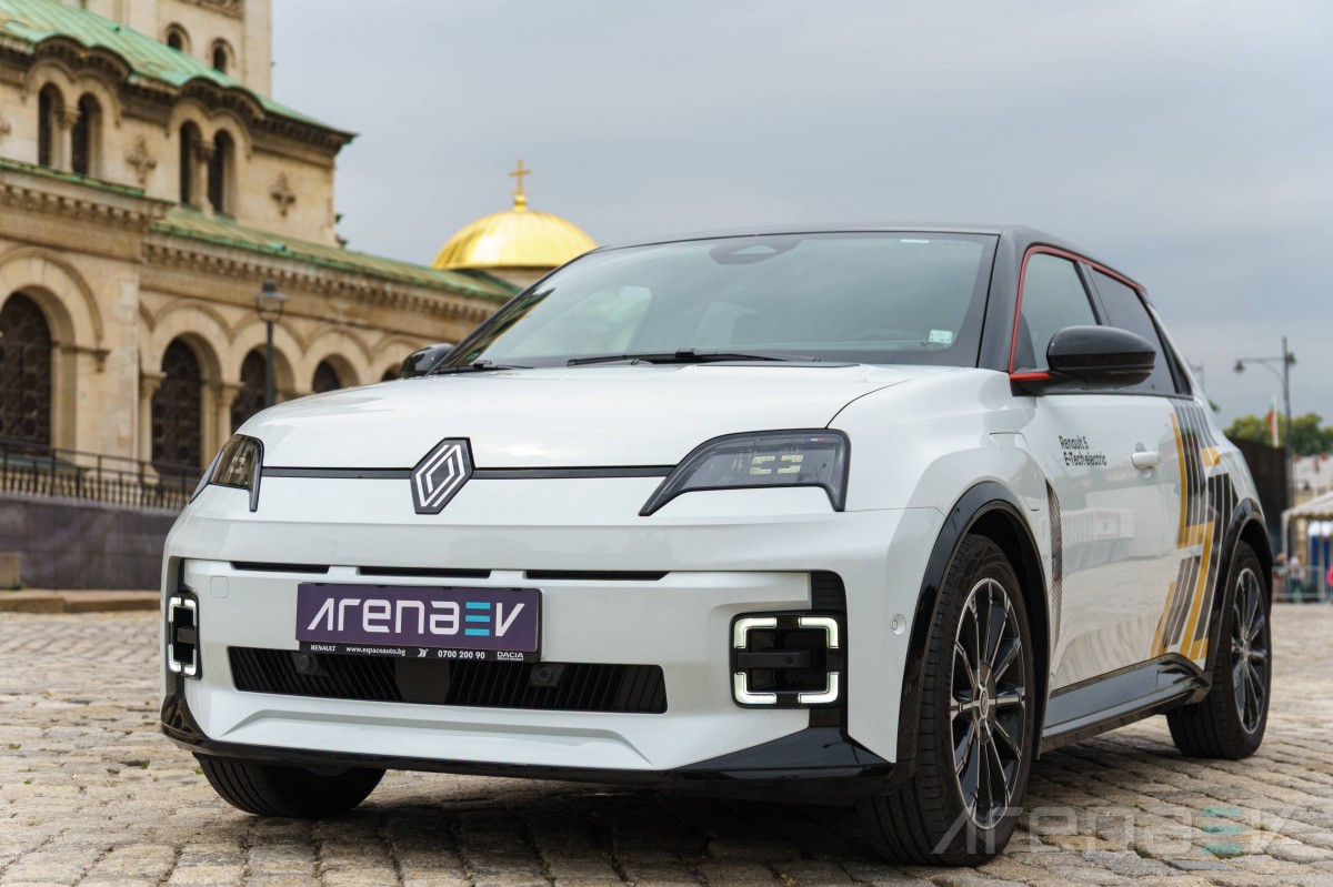 Une Renault 5 E-Tech électrique de 2026, garée dans une rue de ville moderne au crépuscule, ses phares allumés.
