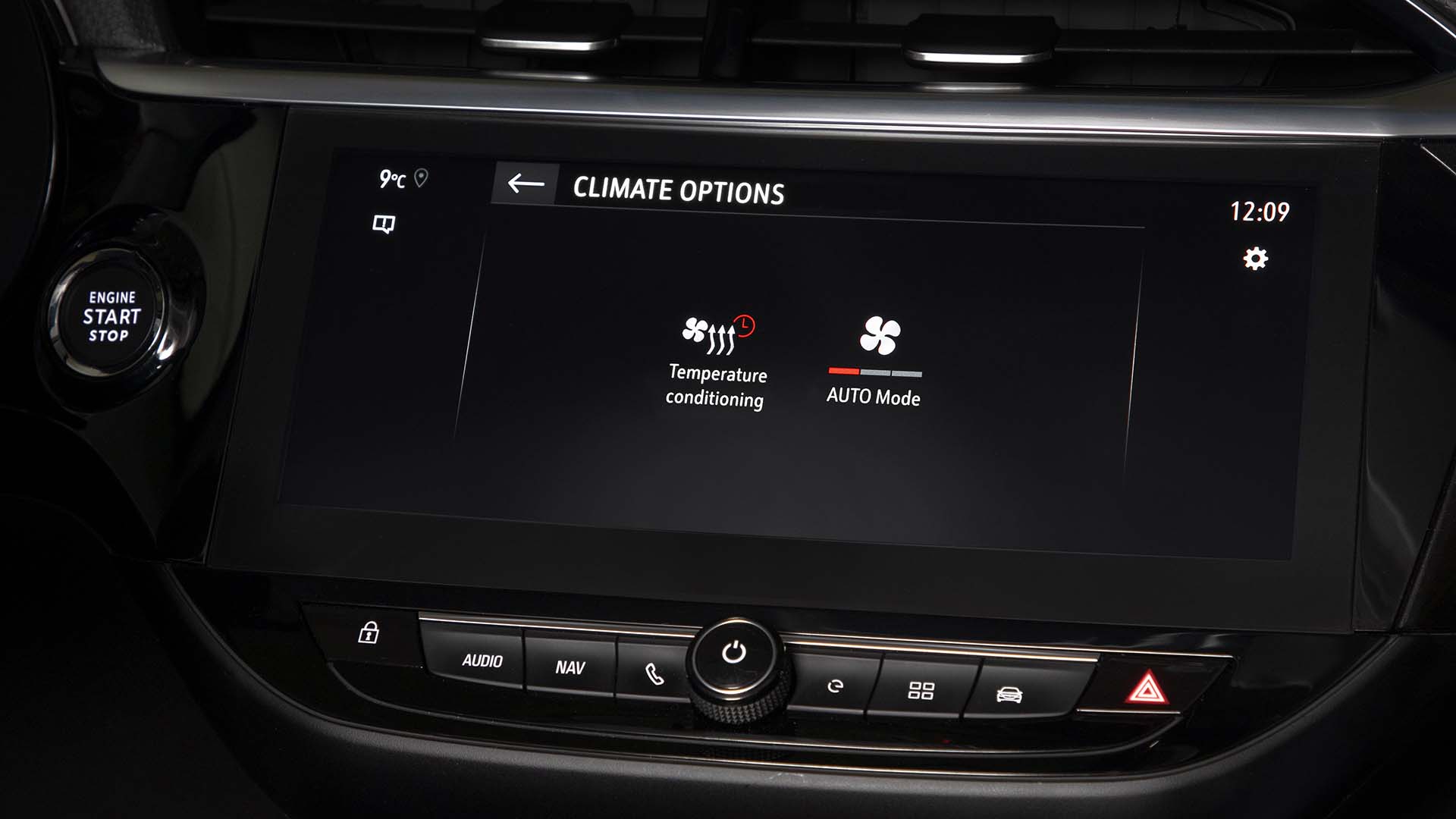 Une voiture électrique Kia EV3 branchée à une borne de recharge dans un paysage enneigé, avec une légère lueur chaude autour du véhicule, illustrant le préconditionnement.