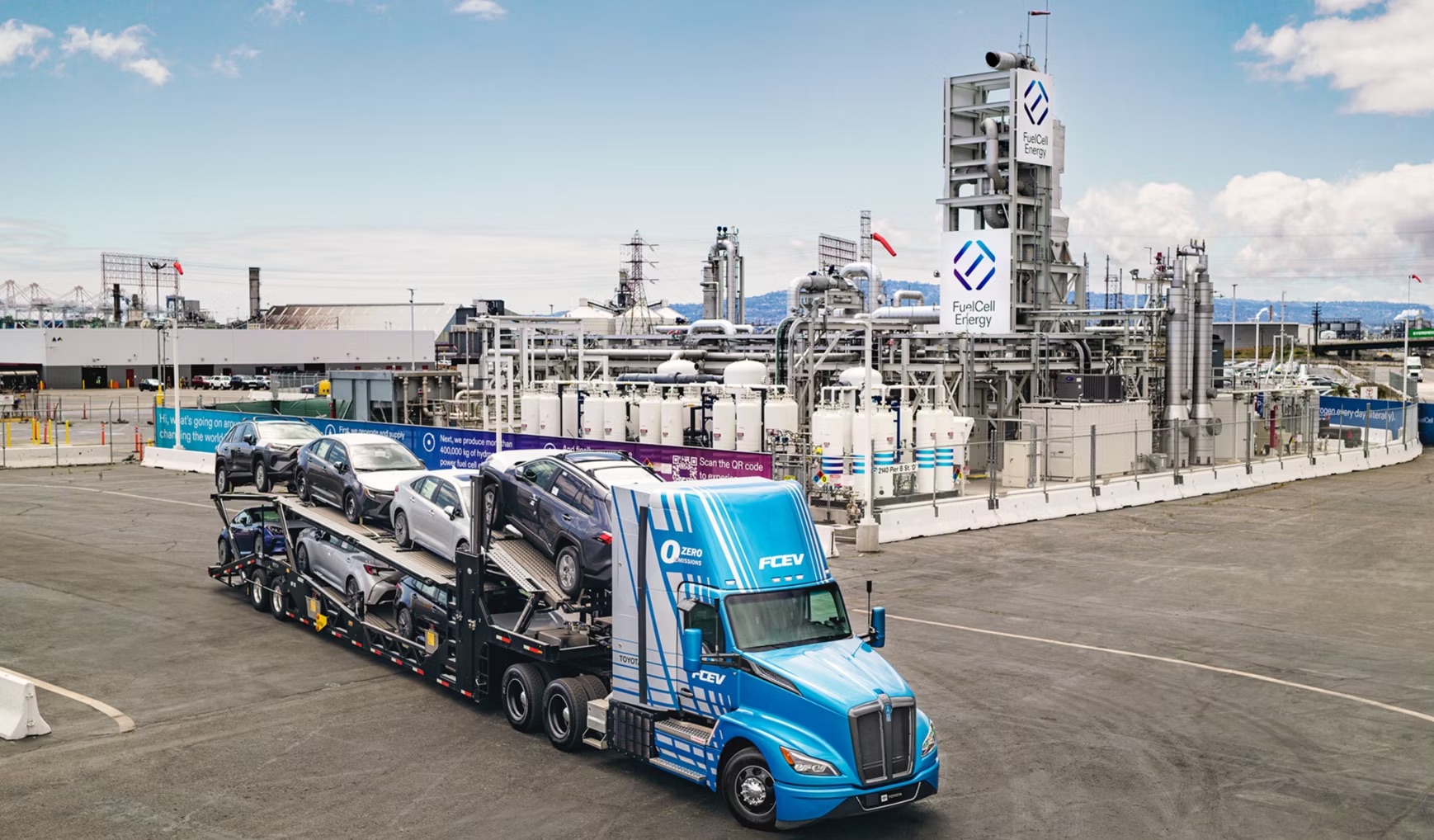Des camions spécialisés transportent des réservoirs d'hydrogène cryogéniques et des stations de ravitaillement mobiles sont installées dans le paddock d'un circuit de course, illustrant la logistique de l'hydrogène.