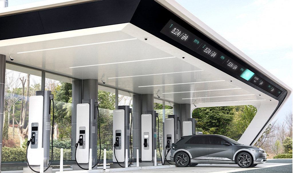 Image d'une borne de recharge ultra-rapide futuriste avec un véhicule électrique en charge, dans un environnement urbain.