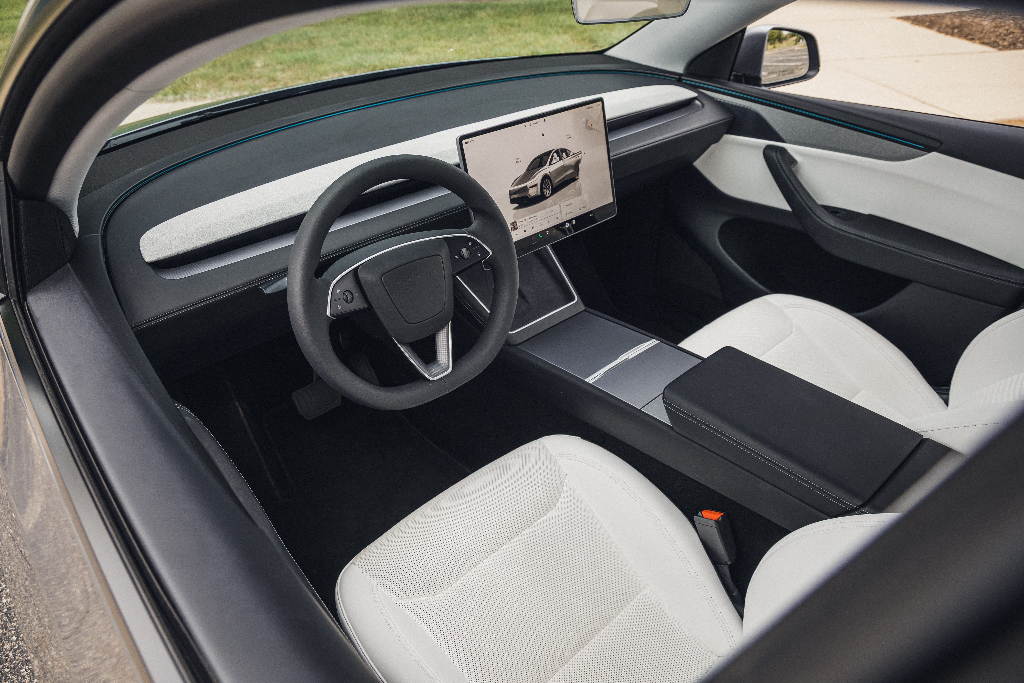 Vue de l'intérieur d'une Tesla Model Y 2026, mettant en évidence le tableau de bord minimaliste et le grand écran tactile central.