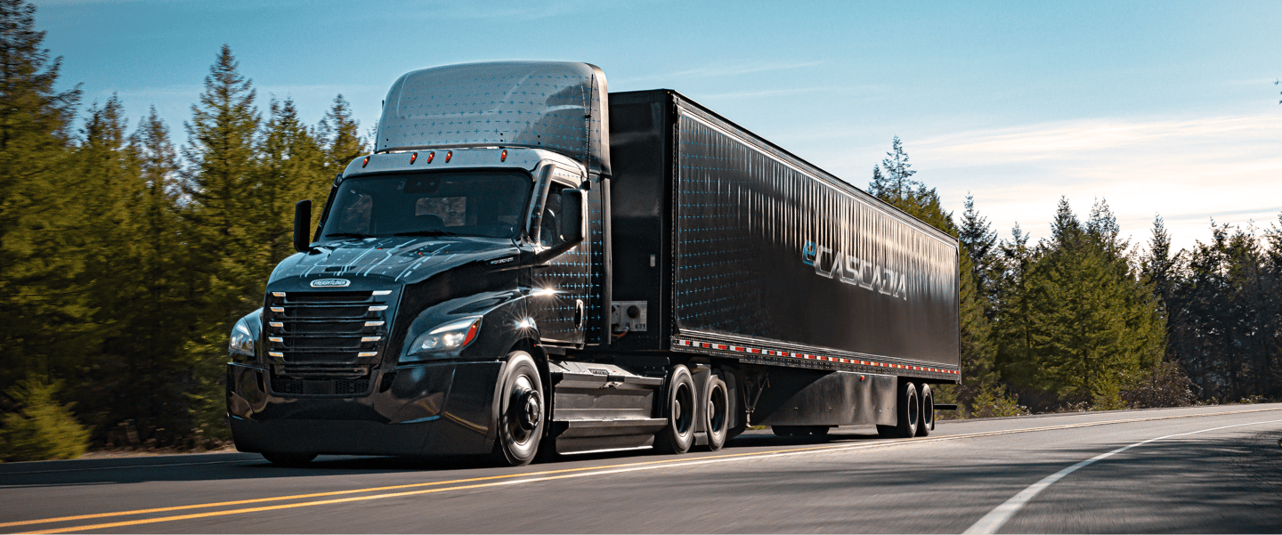 Un camion électrique Freightliner eCascadia roule sur une autoroute, symbolisant la fiabilité des véhicules électriques pour le transport de marchandises.