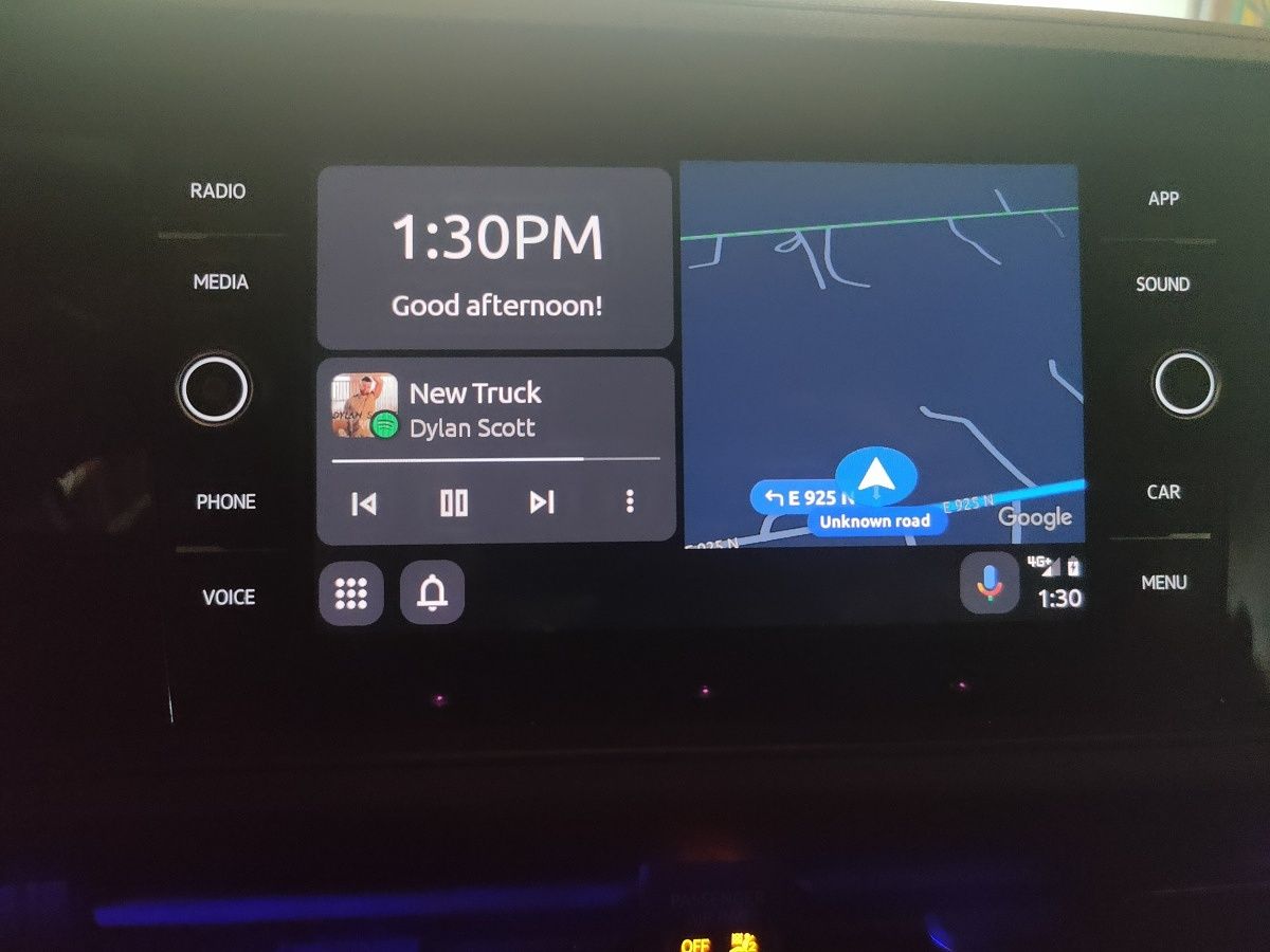Capture d'écran de la nouvelle interface utilisateur d'Android Auto sur un écran de tableau de bord de voiture, affichant des icônes d'applications et des informations de navigation.