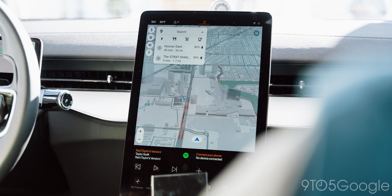 Vue de la navigation Google Maps en 3D sur un écran de voiture, montrant des bâtiments détaillés et des informations routières.