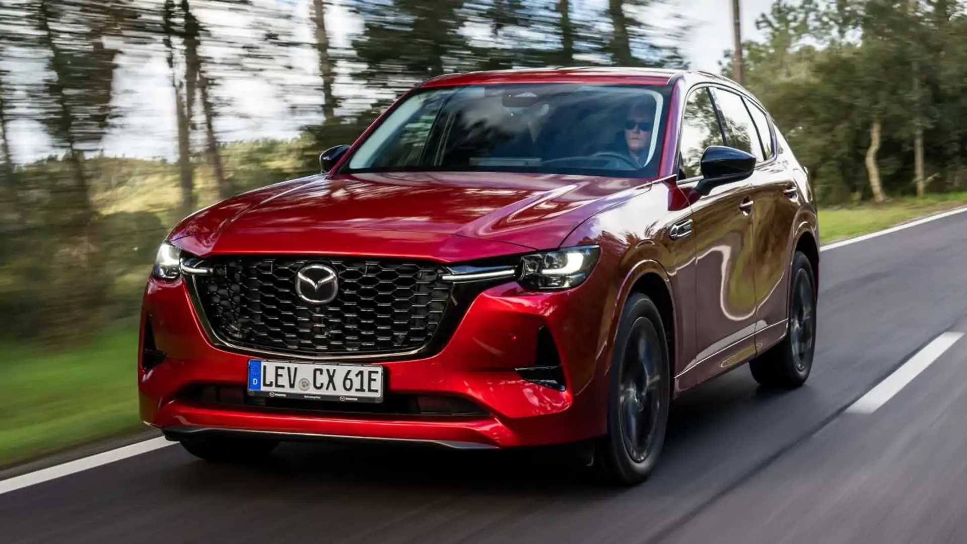Une Mazda CX-60 hybride rechargeable roulant sur une route sinueuse avec un paysage verdoyant en arrière-plan.
