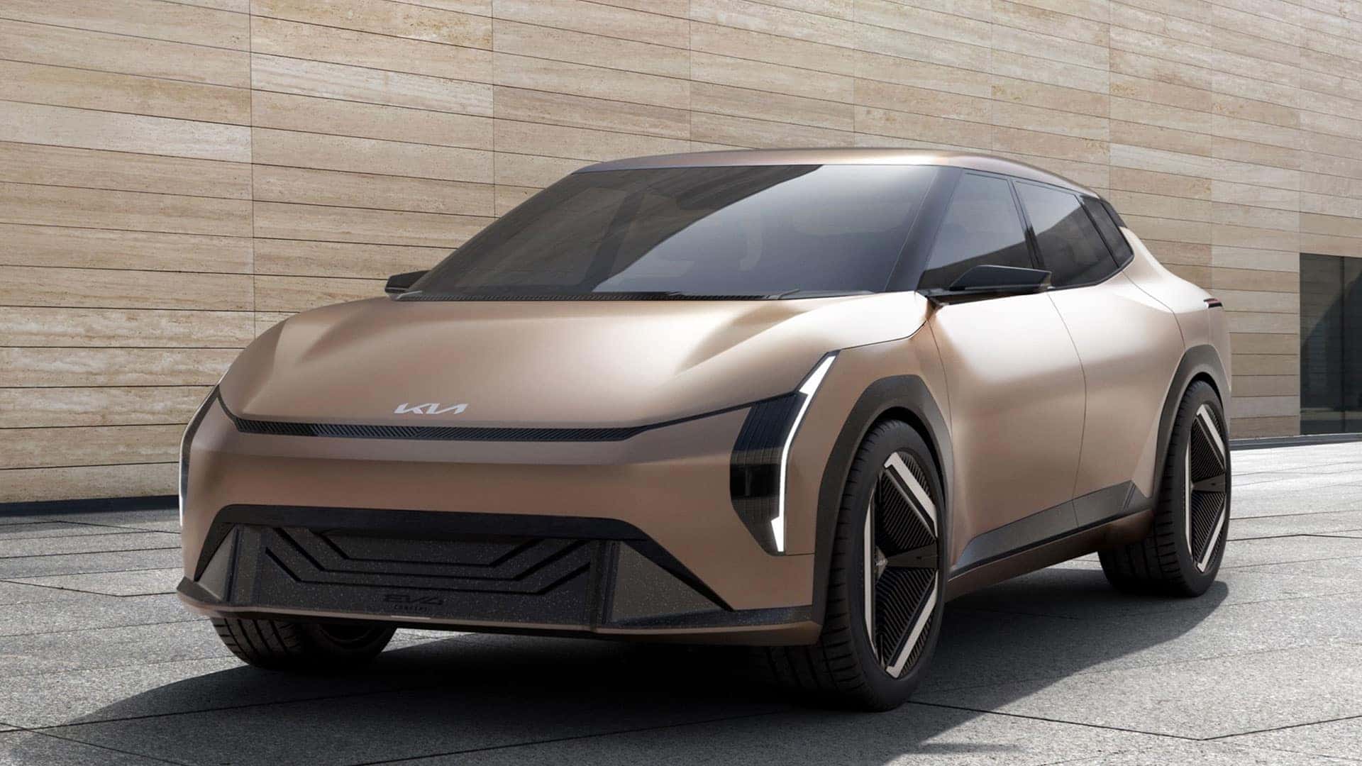 Vue extérieure d'une Kia EV4 concept car, de couleur sombre, avec des phares LED distinctifs et une silhouette aérodynamique, garée dans un environnement urbain moderne.