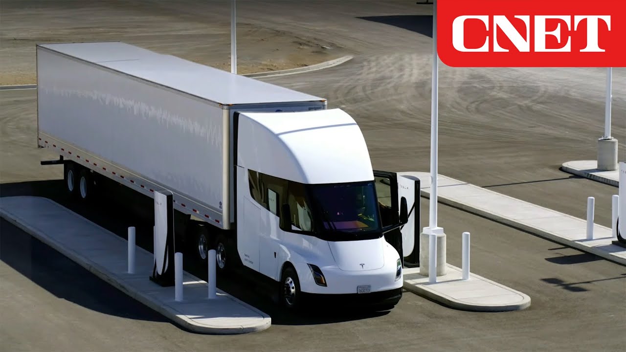 Un camion Tesla Semi blanc roulant sur une autoroute, avec d'autres véhicules en arrière-plan.