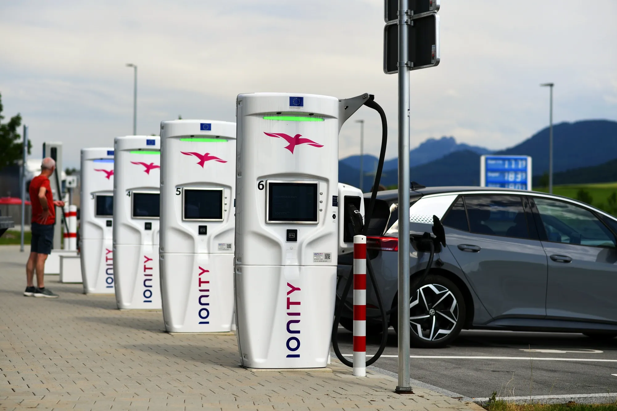 Image d'une borne de recharge moderne pour véhicules électriques dans une ville européenne, avec un véhicule en charge.