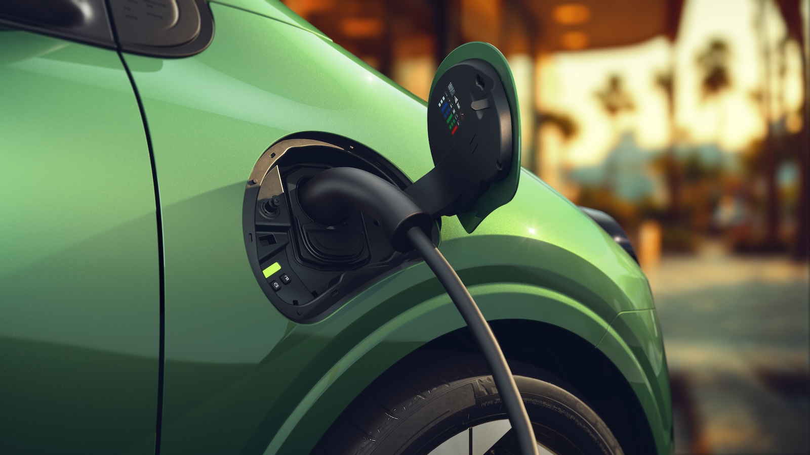 Une Renault Twingo E-Tech électrique branchée à une borne de recharge rapide, avec le câble de recharge bien visible.