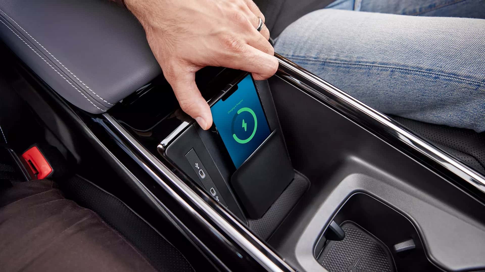 Une Volkswagen Golf électrique futuriste se recharge sans fil sur une borne au sol dans un environnement urbain moderne.