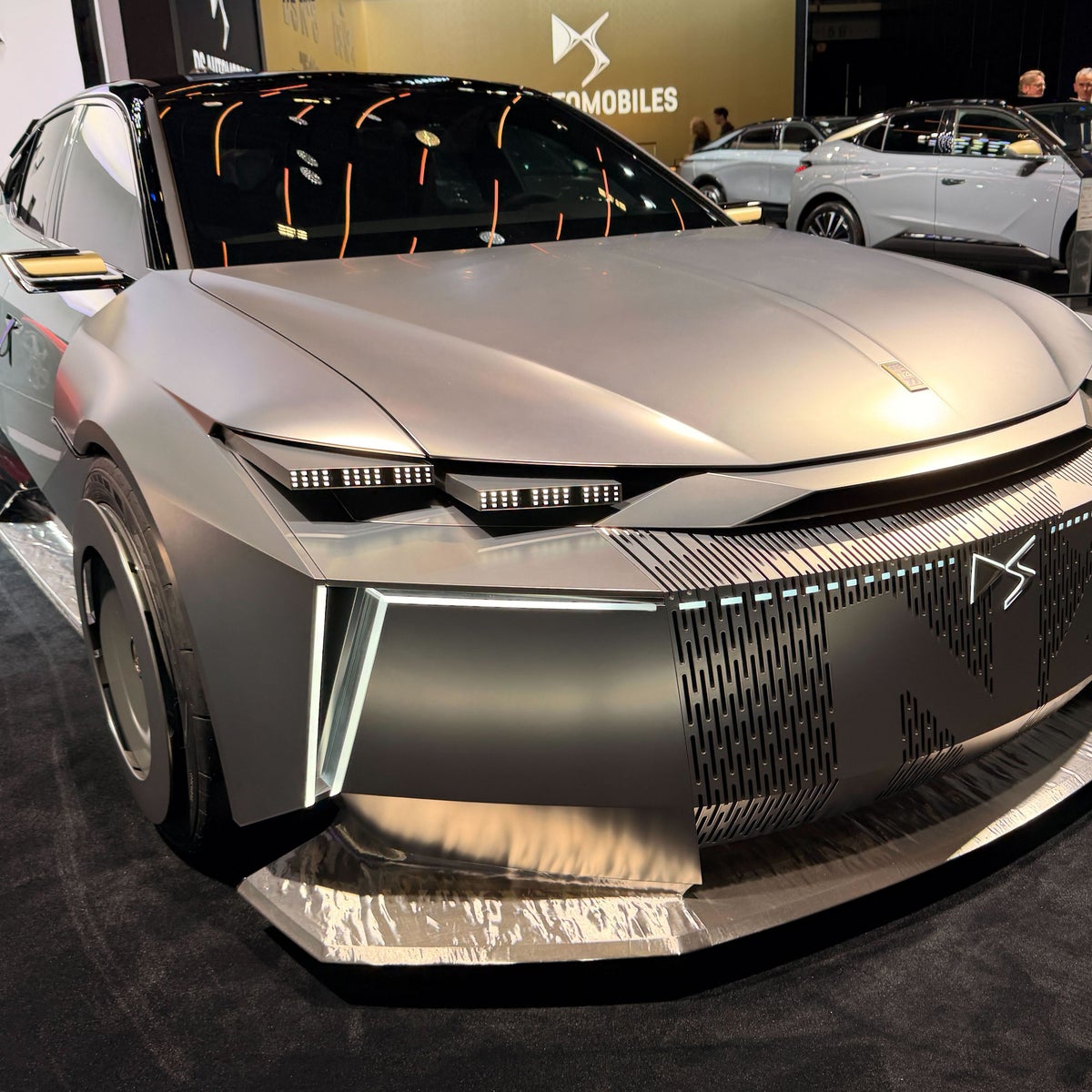 Une DS N°3 2026 électrique concept car, avec une silhouette compacte et des éléments futuristes, dans un environnement urbain.