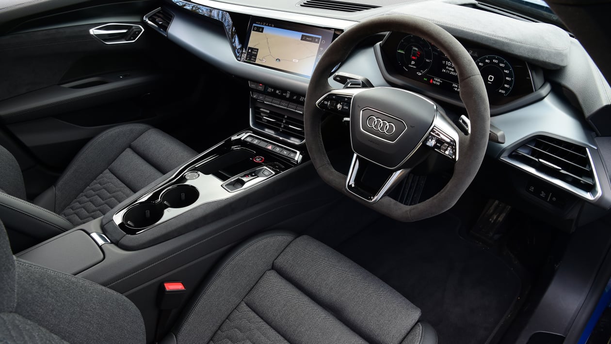 Vue détaillée du tableau de bord de l'Audi e-tron GT, montrant les écrans numériques, les commandes et les matériaux luxueux de l'habitacle.