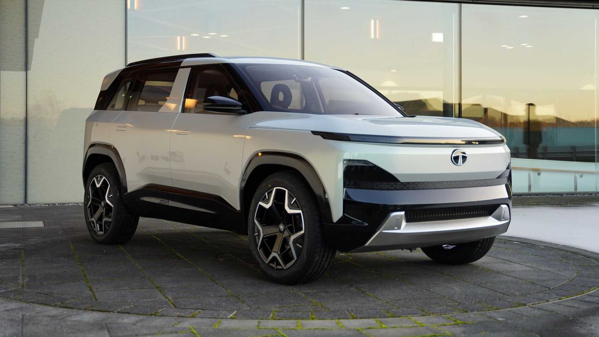 Une image du concept car Tata Sierra EV 2023, un SUV futuriste avec des lignes épurées et des phares LED, garé dans un environnement urbain moderne.