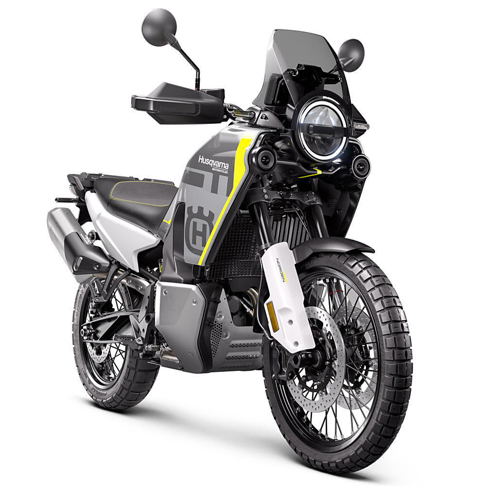 Une moto Husqvarna Norden 901 Expedition blanche et jaune roulant sur un chemin de terre en montagne.
