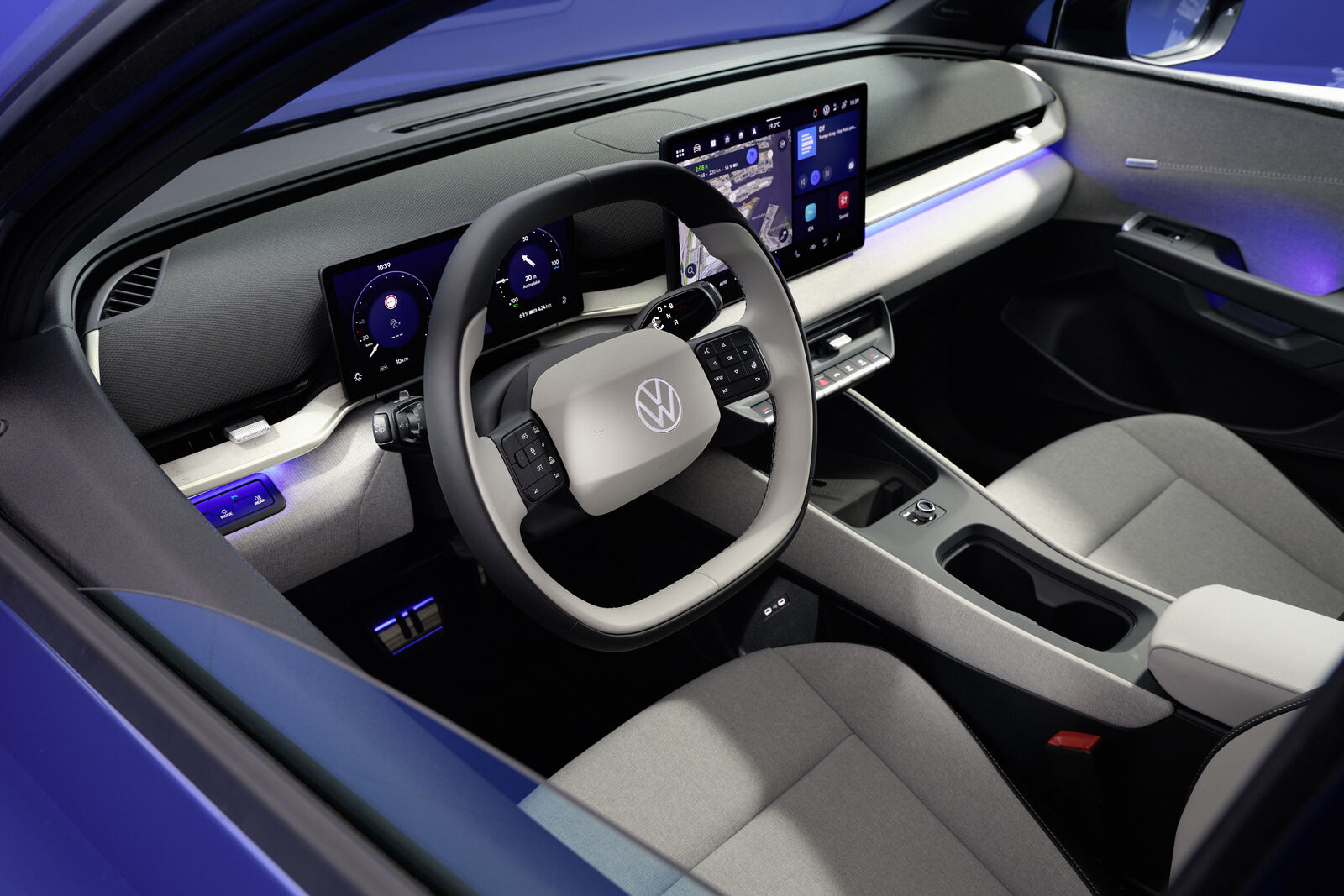 Tableau de bord de la Volkswagen ID. Aero avec un grand écran tactile central et un volant multifonction, illustrant un design intérieur moderne et minimaliste.