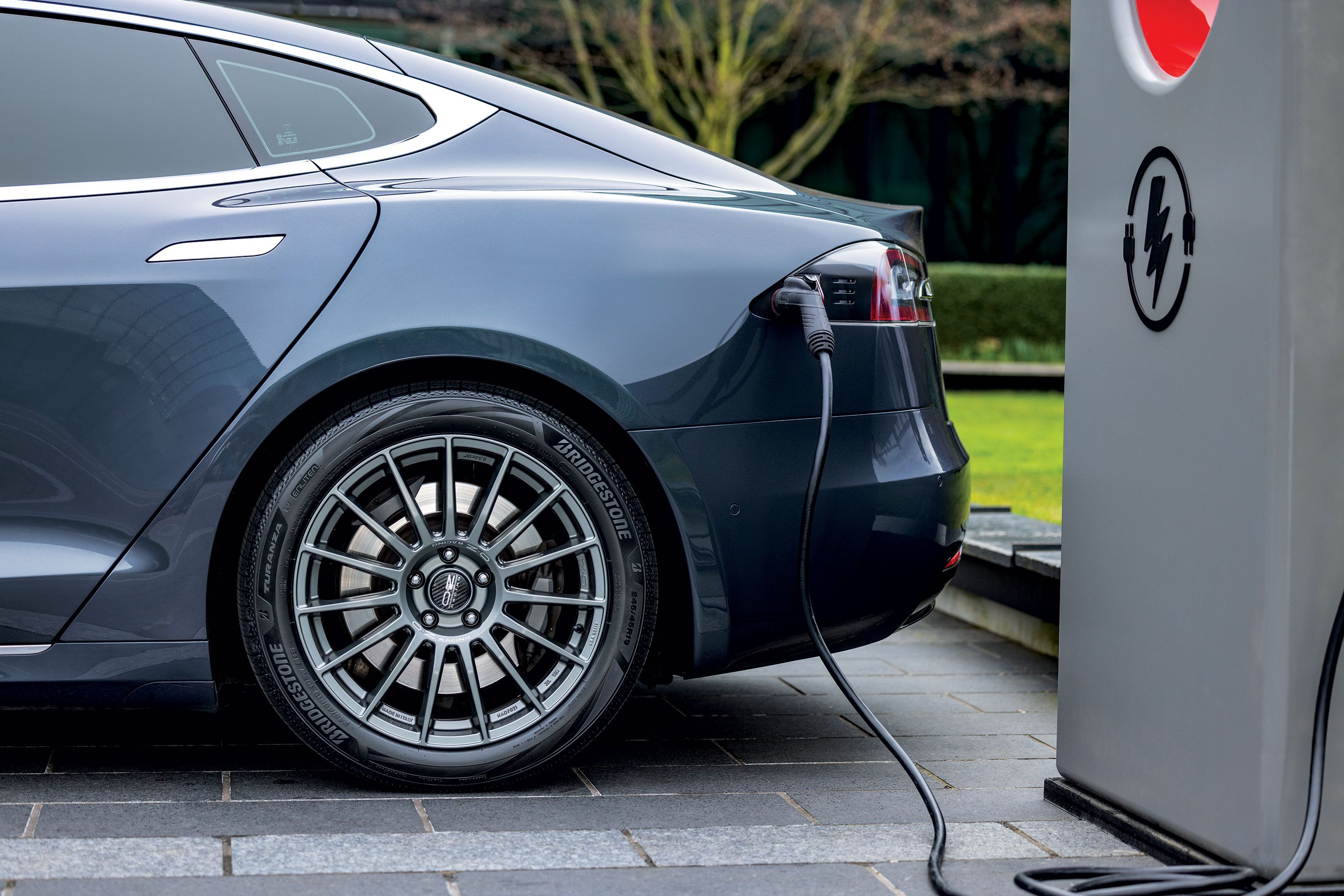 Gros plan sur un pneu de véhicule électrique montrant des signes d'usure, avec une jante moderne.