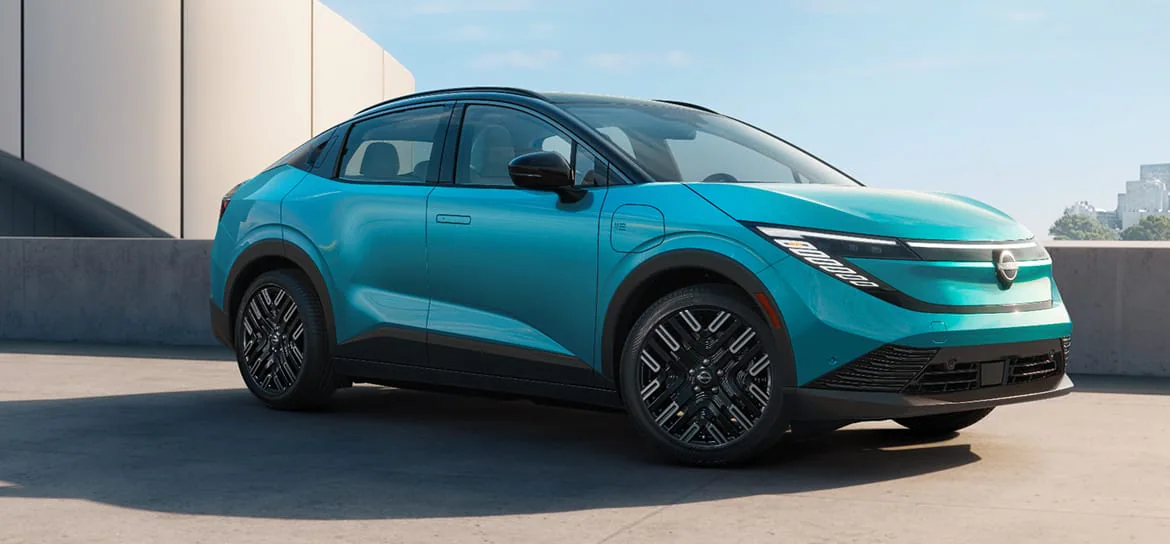 Photo de plusieurs modèles de voitures électriques économiques de 2026, garées dans un showroom lumineux.