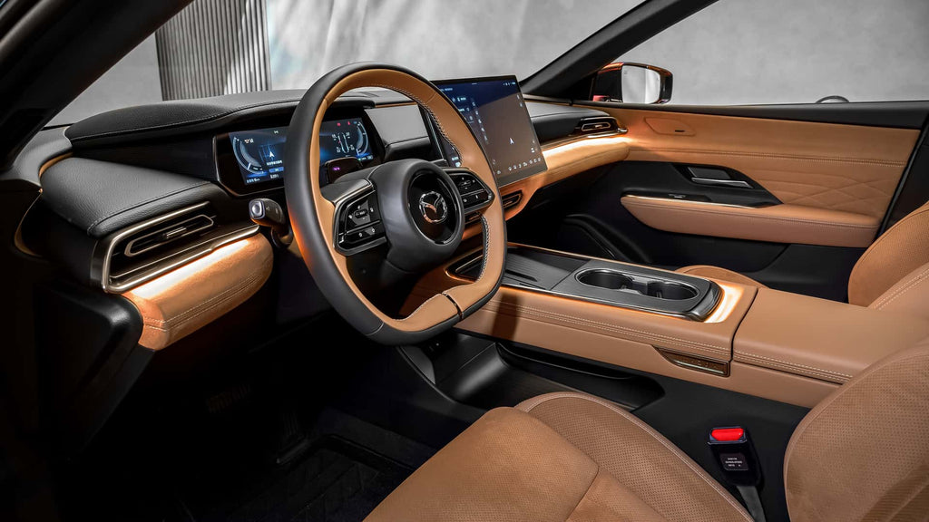Intérieur de la Mazda 6e, montrant les sièges en cuir Nappa, le tableau de bord et le grand écran tactile.