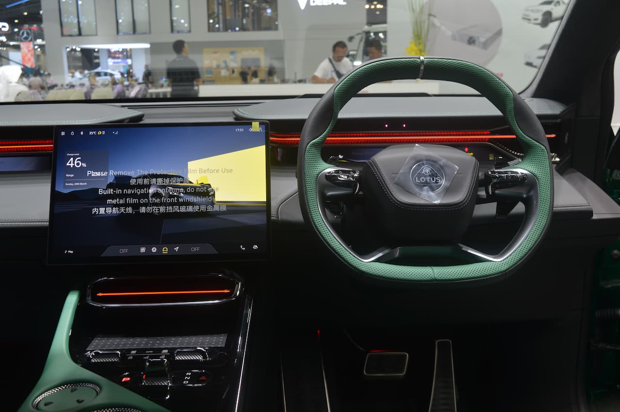 Intérieur du Lotus Eletre X, montrant le tableau de bord numérique, le grand écran central et les sièges en cuir noir avec des accents rouges.