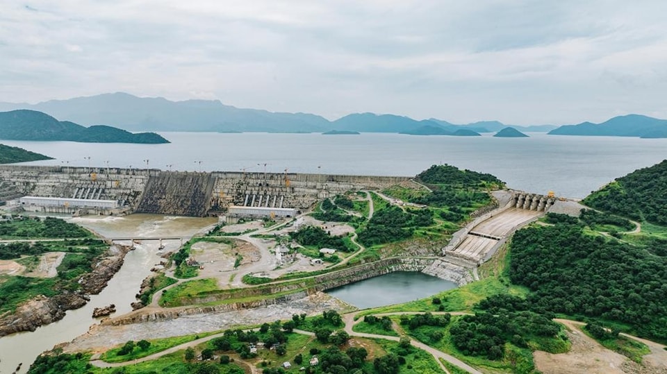 Vue aérienne du Grand Barrage de la Renaissance Éthiopienne, un immense barrage hydroélectrique sur le Nil Bleu, entouré de verdure.