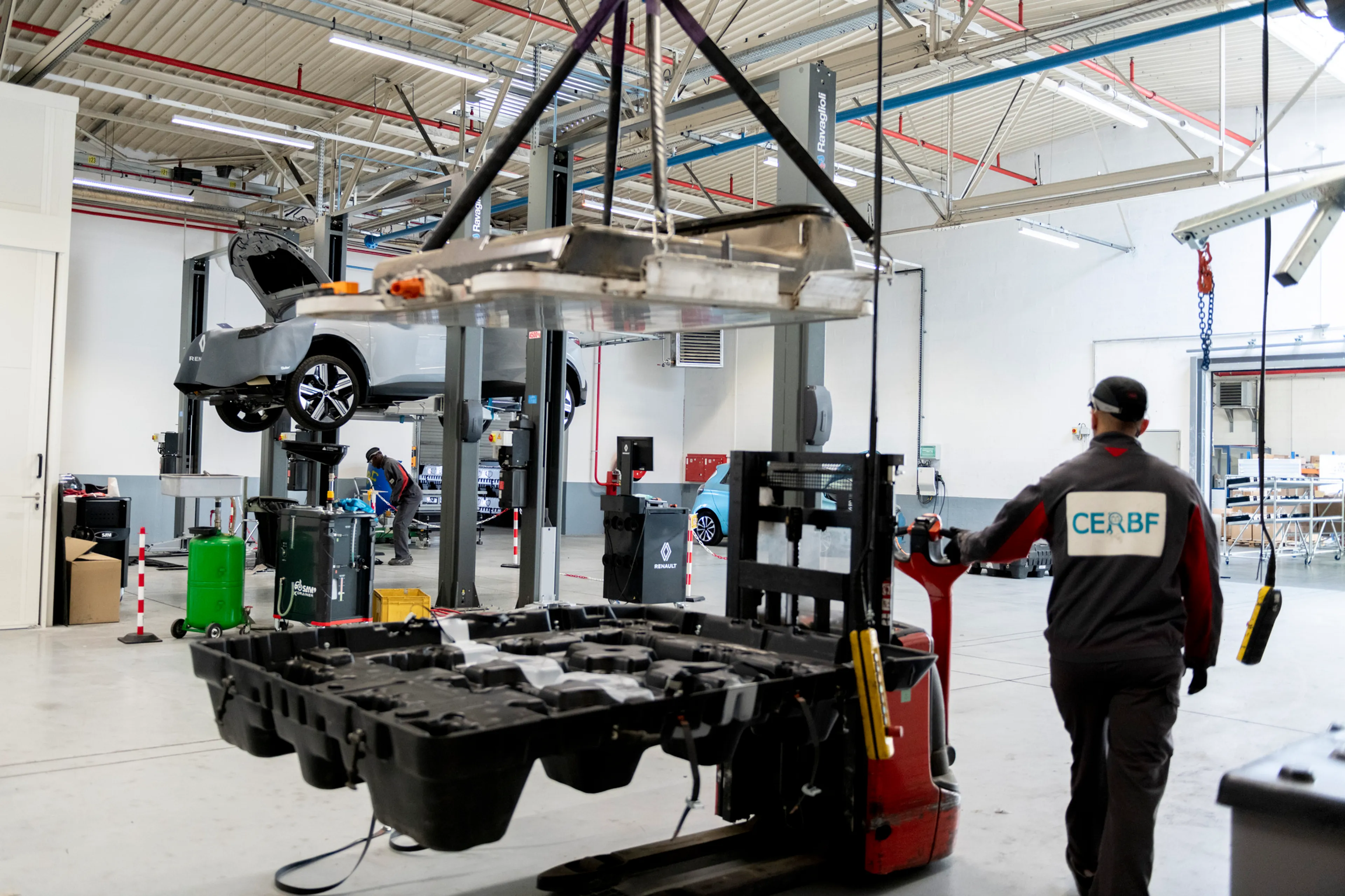 Vue intérieure d'une usine de recyclage de batteries, montrant des machines sophistiquées en train de démonter des batteries de véhicules électriques.