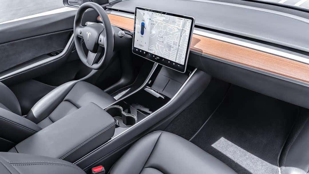 Intérieur d'un Tesla Model Y avec l'écran tactile central de 15 pouces affichant une carte.