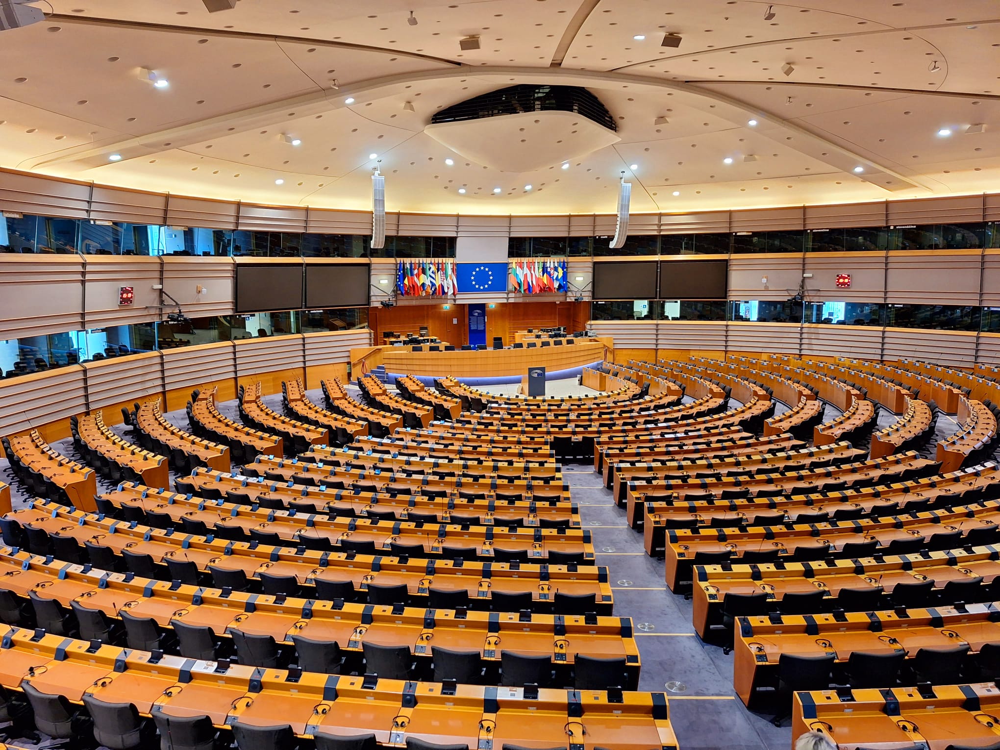 Vue extérieure du Parlement européen, un bâtiment moderne et imposant, sous un ciel bleu.