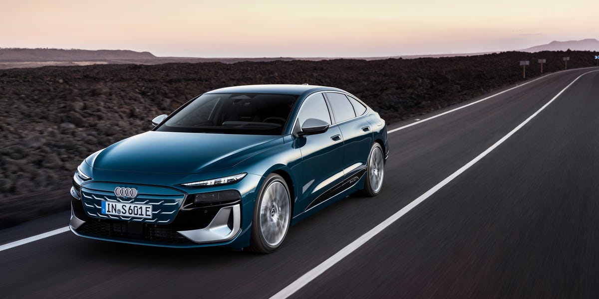 Une Audi A6 e-tron noire en mouvement sur une autoroute, vue de trois quarts avant.