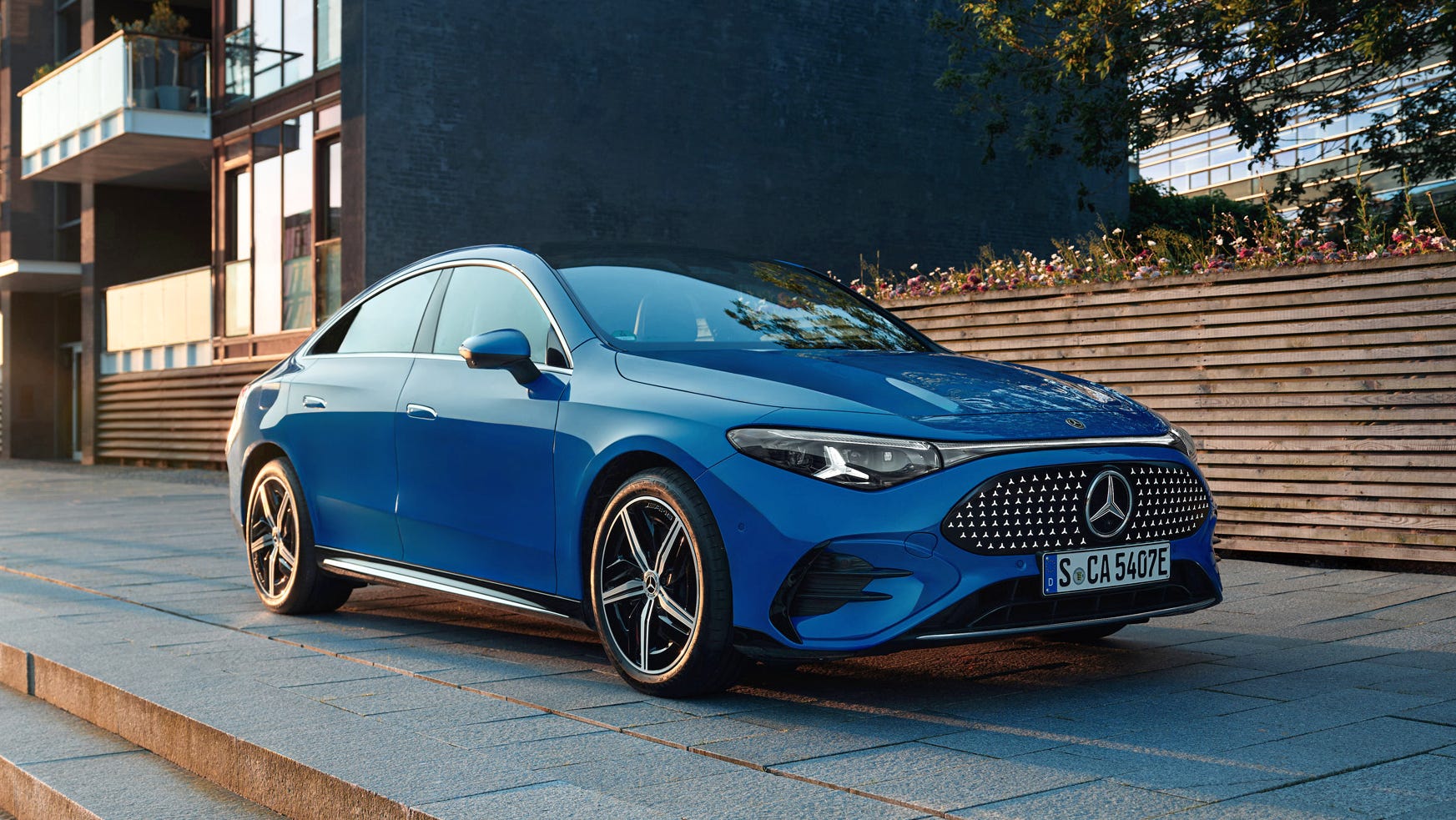 Une Mercedes CLA électrique grise en charge sur une borne rapide, le câble de recharge bien visible.