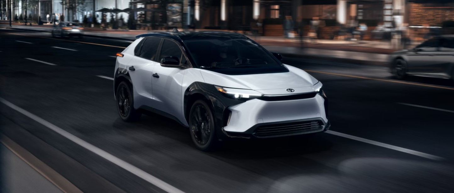 Un SUV électrique Toyota bZ4X blanc en mouvement sur une route de montagne.
