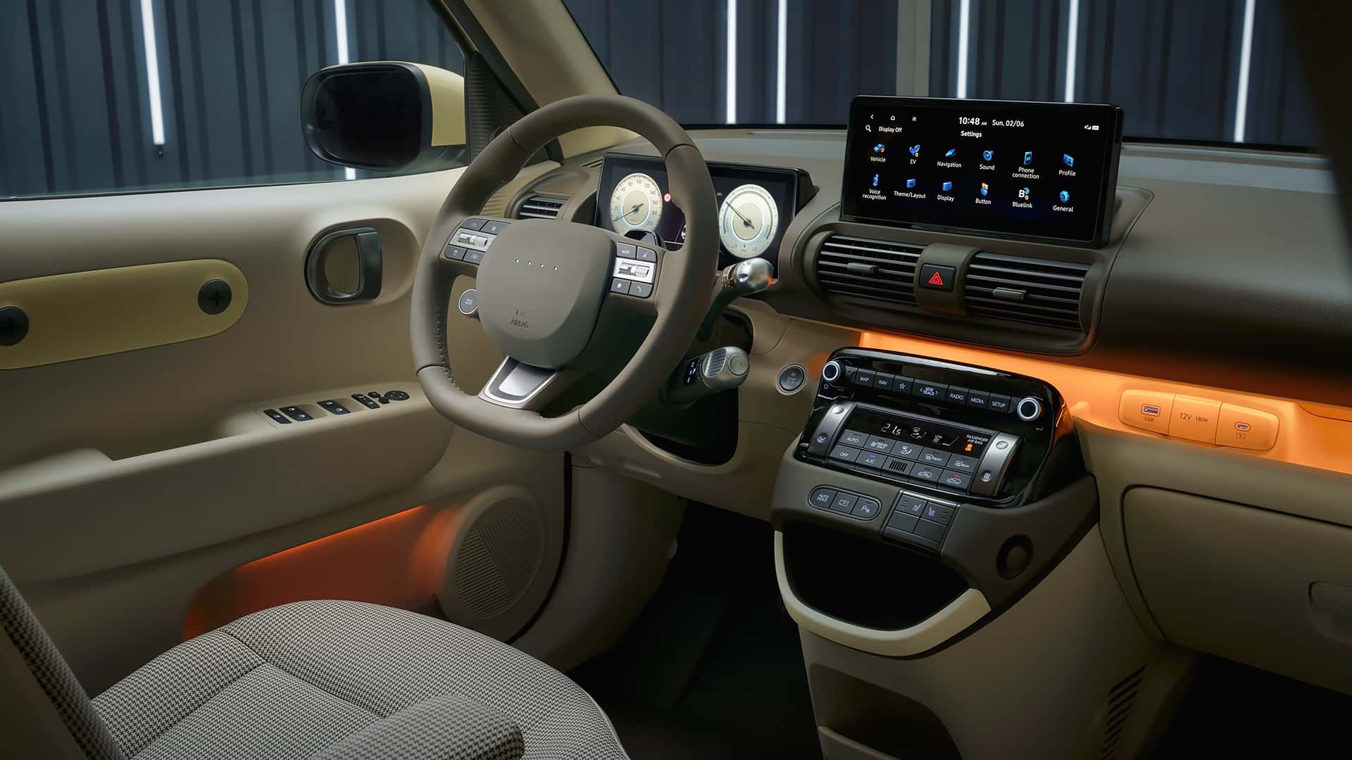 Vue de l'intérieur de la Hyundai Inster, mettant en avant l'espace généreux, les sièges modulables et le tableau de bord moderne avec écran tactile.
