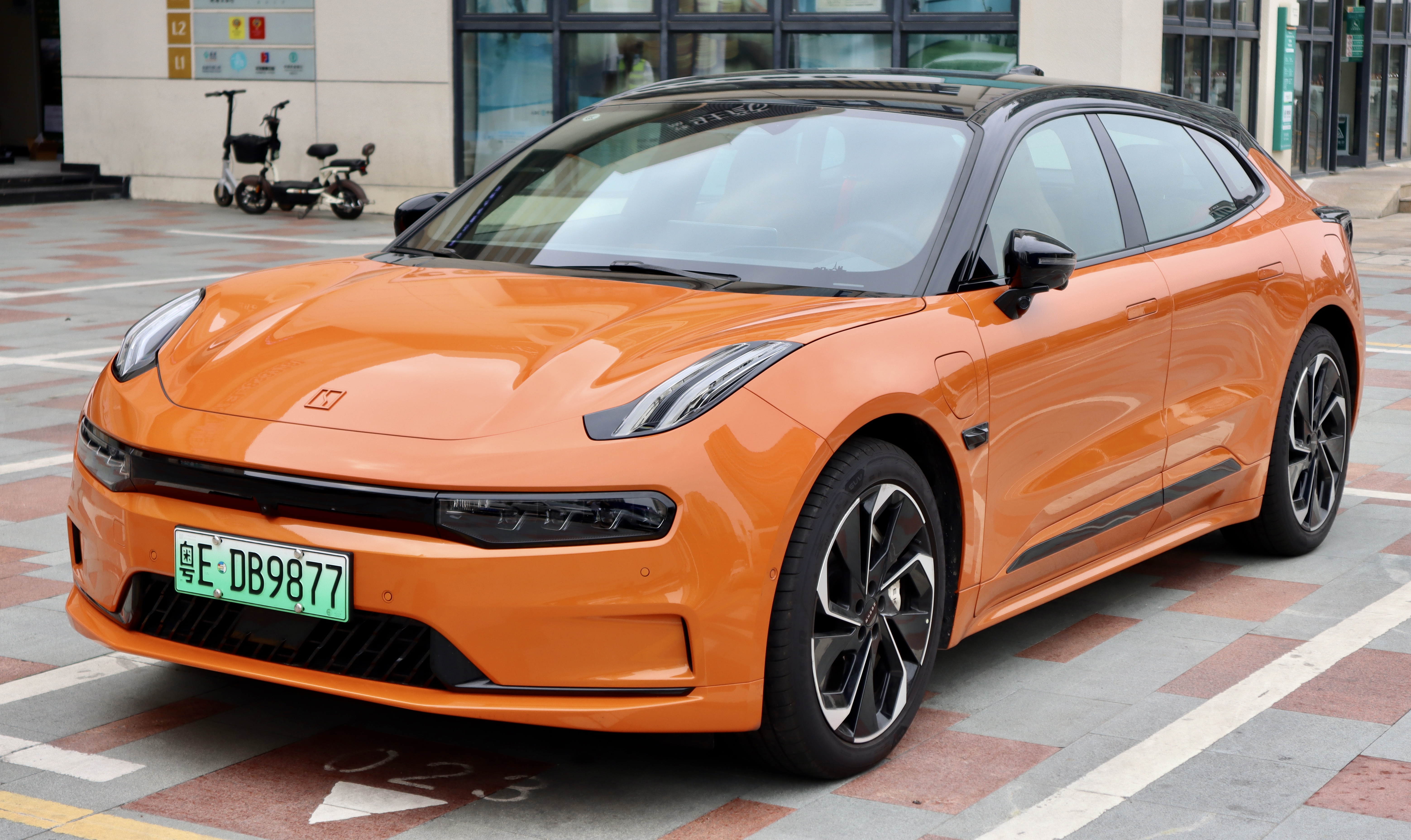 Une voiture électrique Zeekr 001 en mouvement sur une route panoramique.