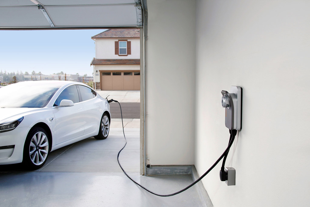 Une voiture électrique branchée à une borne de recharge à domicile.