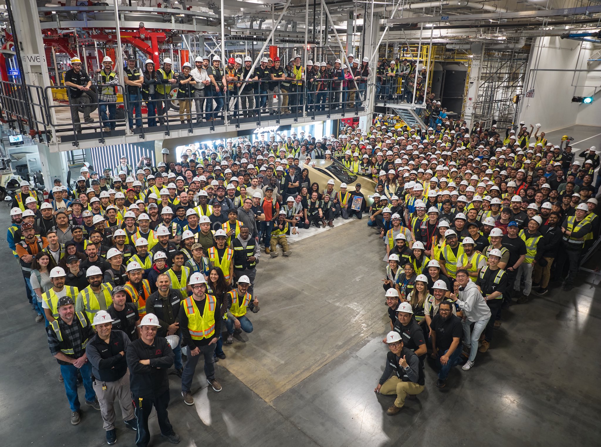 Scène de production dans l'usine Tesla Giga Texas, montrant des robots assemblant des modules de Cybercab.