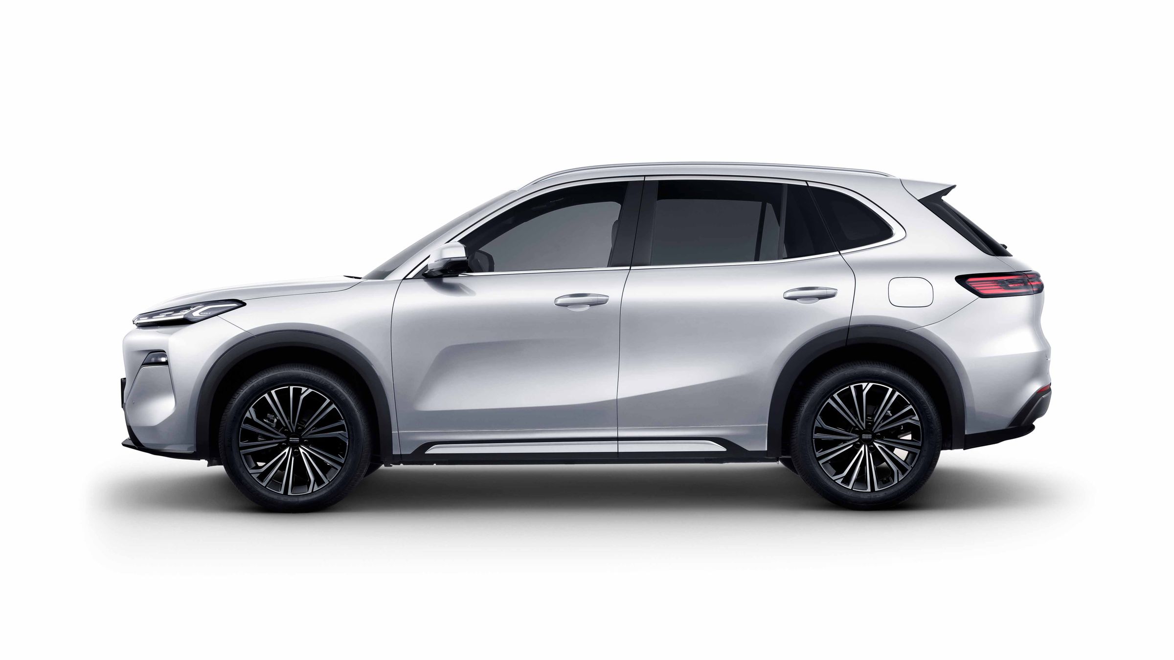 Vue extérieure du SUV hybride rechargeable Geely Starray EM-i, de couleur claire, garé dans une rue de ville moderne.