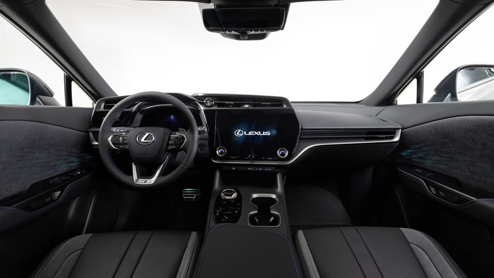 Vue intérieure du Lexus RZ 350e, mettant en évidence l'écran tactile central, les sièges en cuir et le volant multifonction.