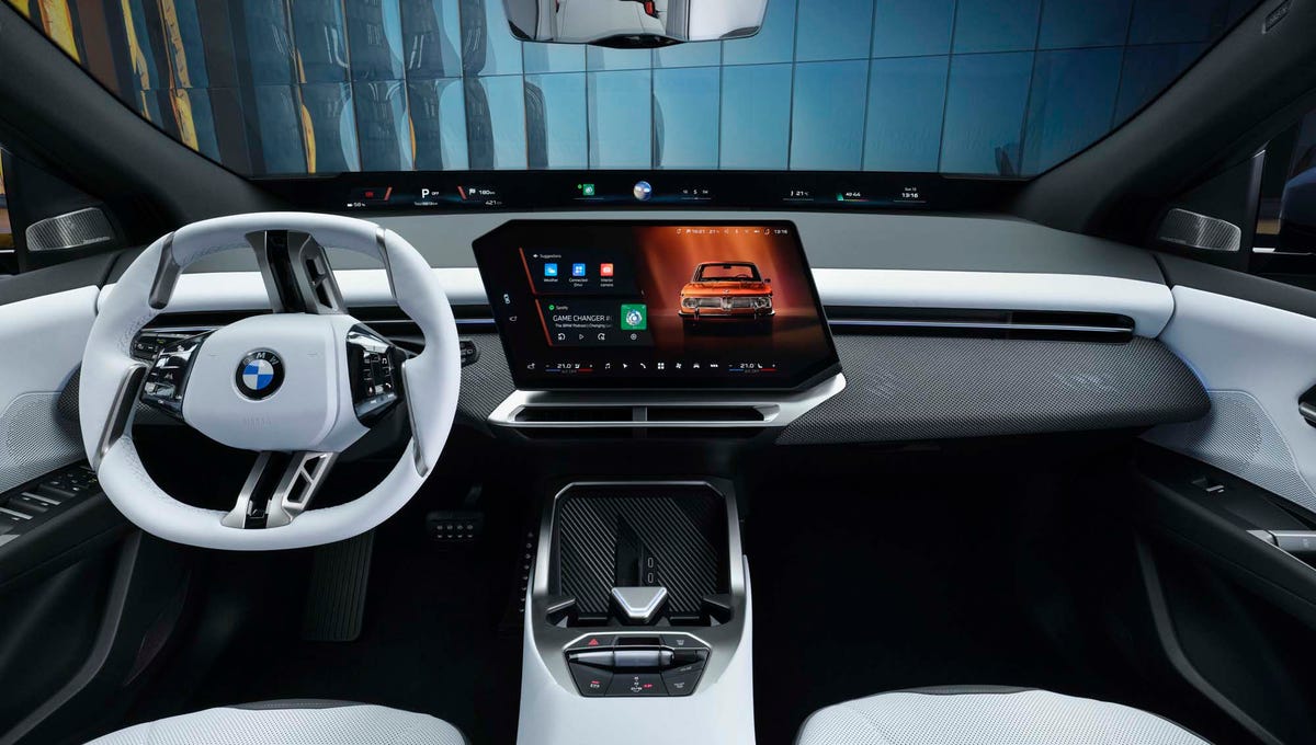 Intérieur du BMW iX3, montrant le tableau de bord numérique et l'écran tactile central, avec des matériaux de haute qualité.