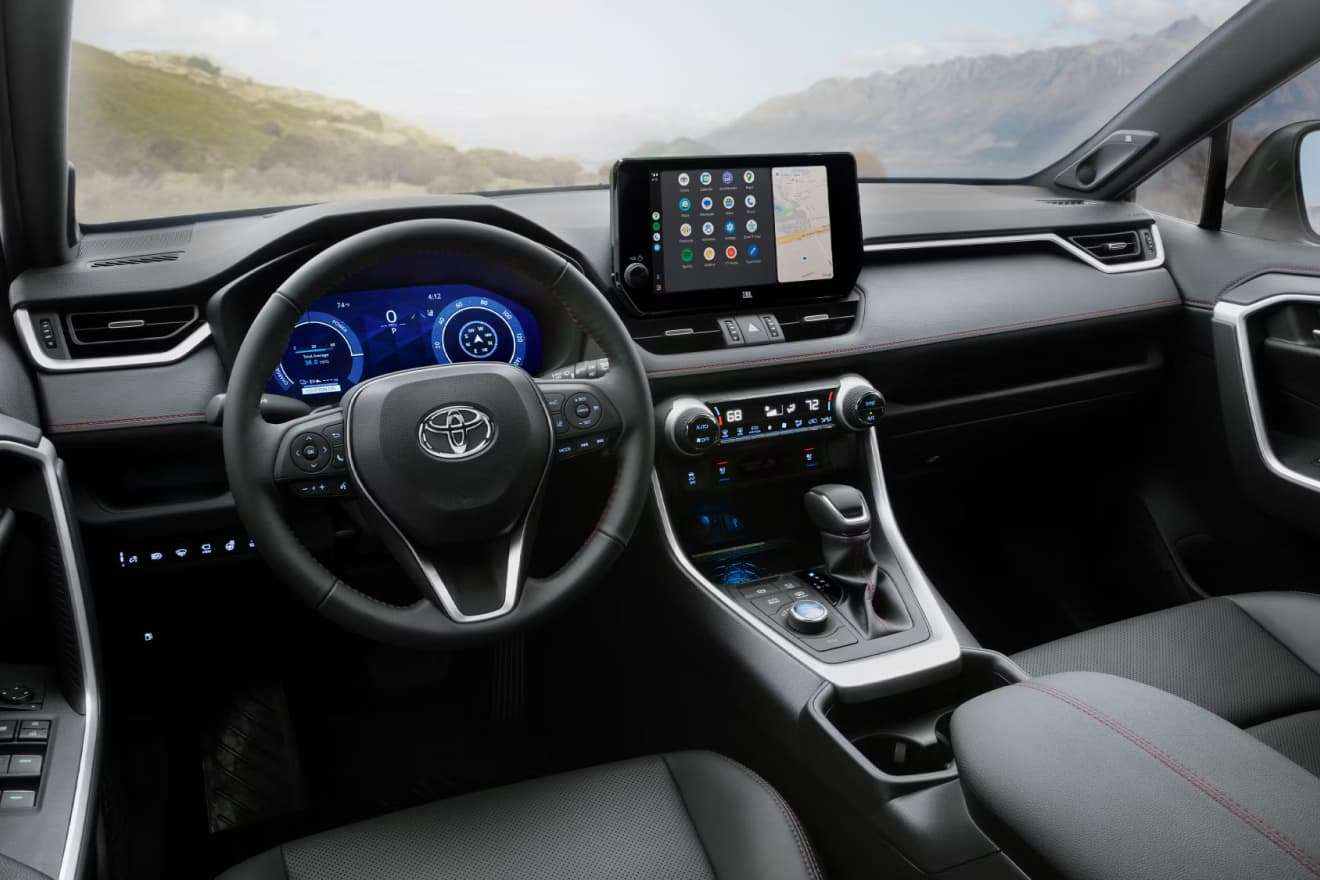Intérieur du Toyota RAV4 PHEV 2025, montrant le grand écran tactile central et le tableau de bord moderne.