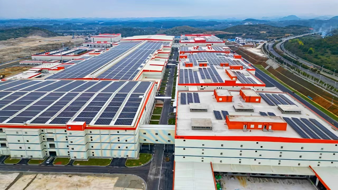Vue intérieure d'une usine de batteries CATL, montrant des lignes d'assemblage automatisées et des robots en pleine activité.