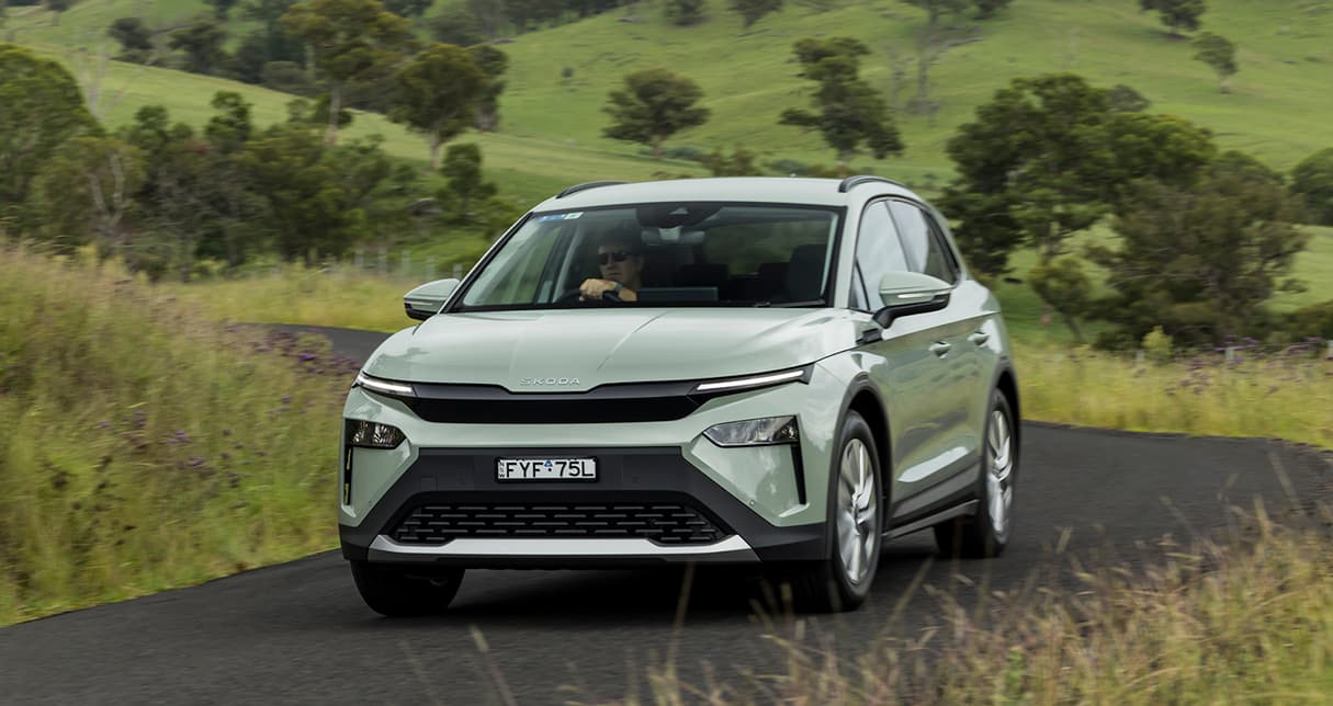 Un SUV électrique Skoda Elroq blanc en mouvement sur une route européenne, avec un paysage moderne ou naturel en arrière-plan.