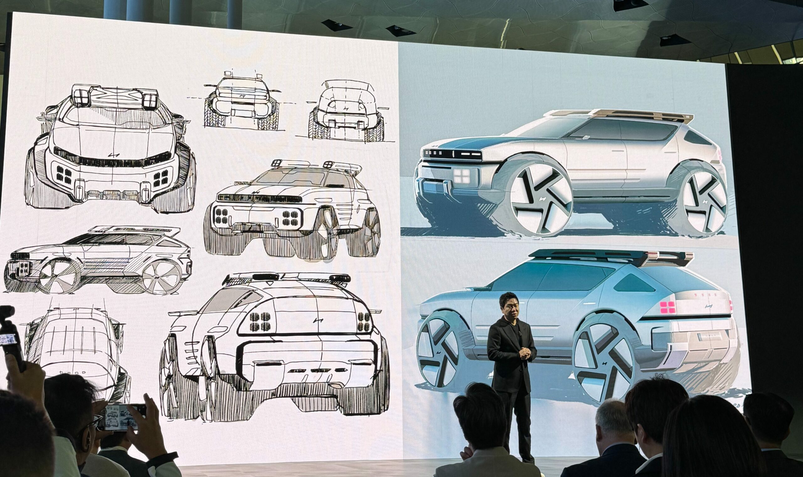 Une voiture Hyundai moderne et élégante, illustrant le nouveau langage de conception unifié de la marque, avec des lignes épurées et une calandre distinctive, dans un environnement urbain futuriste au crépuscule.