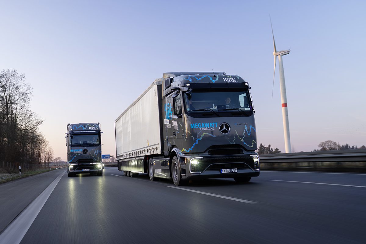 Un camion électrique Mercedes eActros 600 bleu foncé roule sur une autoroute moderne sous un ciel clair.