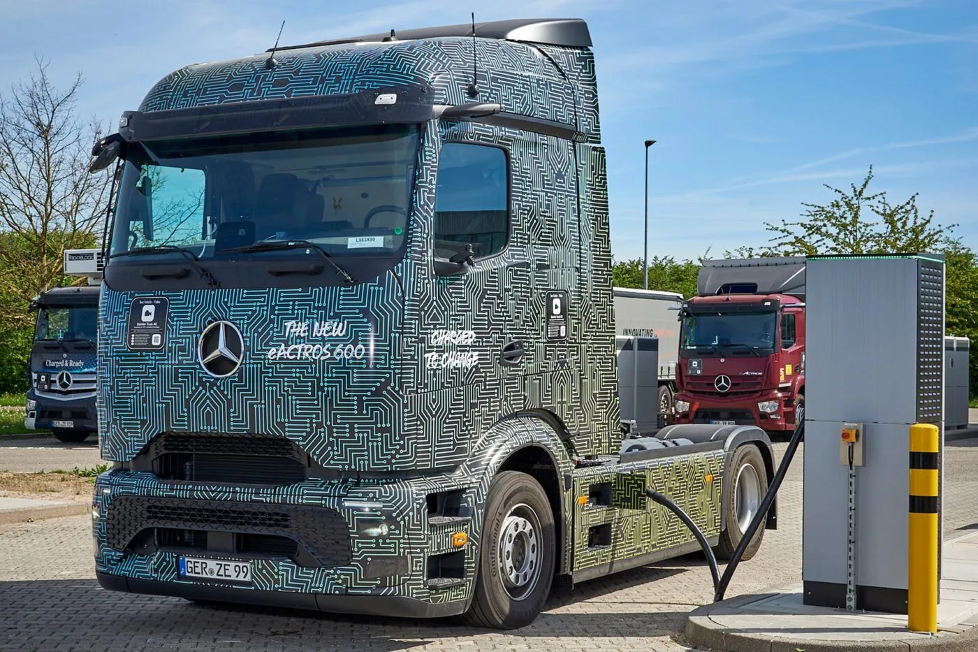 Un camion électrique Mercedes eActros 600 est connecté à une borne de recharge rapide dans une station moderne.