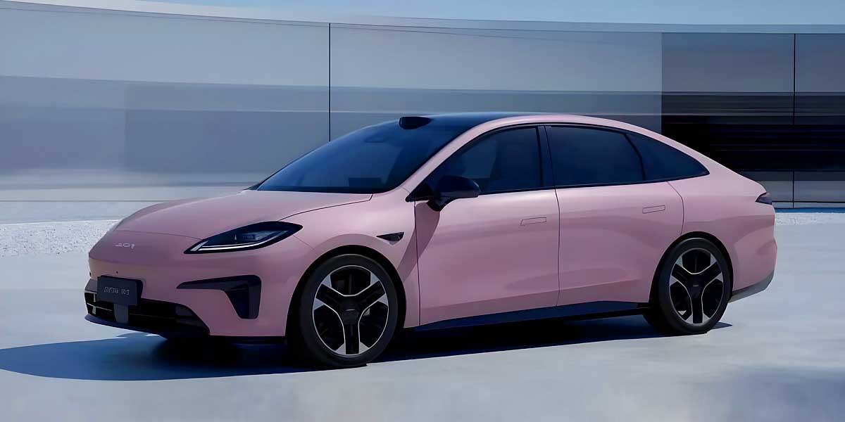 Une voiture électrique Aion RT Super de couleur foncée roulant sur une autoroute moderne.