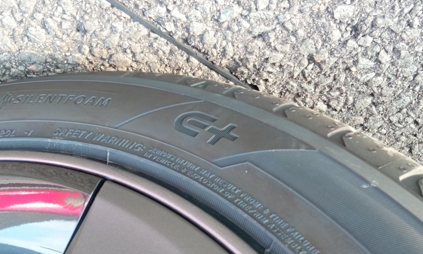 Gros plan sur le flanc d'un pneu de véhicule électrique neuf, montrant un marquage spécifique aux VE.