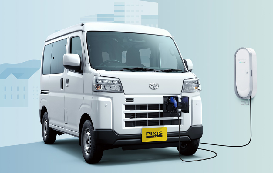 Deux mini-vans électriques, un Toyota Pixis Van BEV et un Daihatsu e-Hijet Cargo, garés dans une rue urbaine moderne, mettant en évidence leur design compact et leur aptitude à la ville.