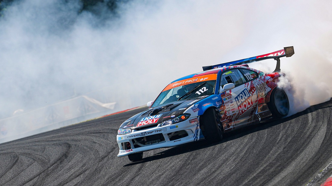 Gros plan sur la roue arrière et la suspension d'une voiture de drift, montrant les modifications apportées pour améliorer la performance.